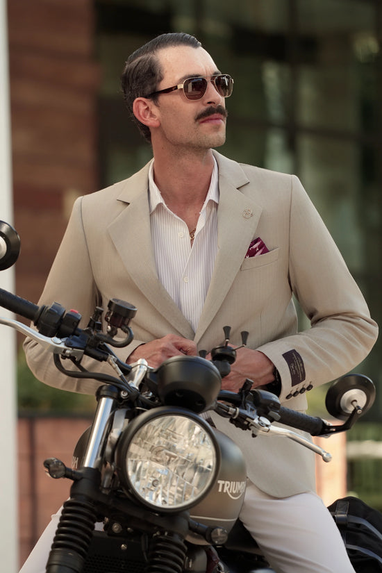 Man in the Brummell x DGR Limited Edition motorcycle blazer sitting on a Triumph motorcycle, highlighting the blazer’s refined and tailored silhouette.